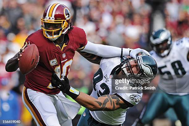 Quarterback Robert Griffin III of the Washington Redskins stiff arms defensive end Jason Babin of the Philadelphia Eagles in the second quarter at...