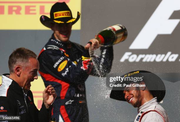 Race winner Lewis Hamilton of Great Britain and McLaren celebrates on the podium alongside second placed Sebastian Vettel of Germany and Red Bull...