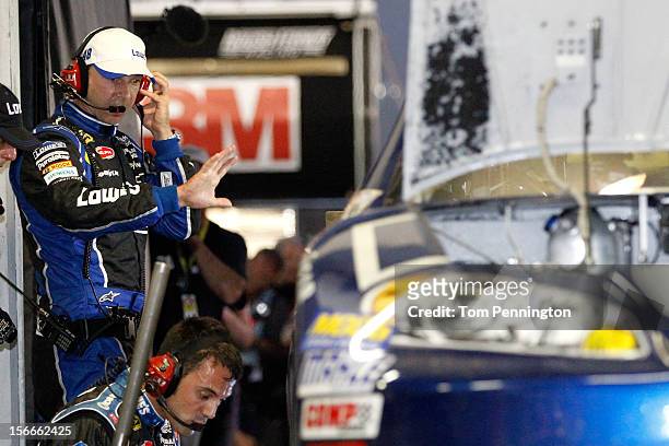 Crew chief Chad Knaus looks over the Lowe's Chevrolet as crew members work on it in the garage after an incident in the NASCAR Sprint Cup Series Ford...