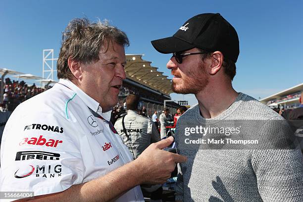 Actor Michael Fassbender talks with Norbert Haug of Mercedes on the grid before the United States Formula One Grand Prix at the Circuit of the...