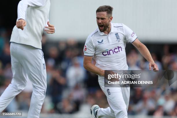 England's Chris Woakes celebrates after taking the wicket of Australia's Steven Smith on day five of the fifth Ashes cricket Test match between...