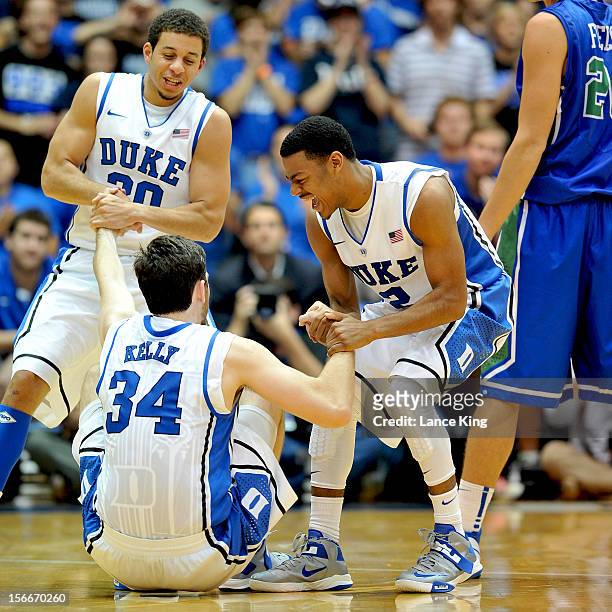 Seth Curry and Quinn Cook help Ryan Kelly of the Duke Blue Devils off the floor against the Florida Gulf Coast Eagles at Cameron Indoor Stadium on...