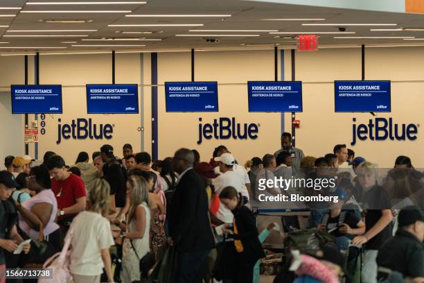 Travelers line up to check-in for JetBlue flights in Terminal 5 at John F. Kennedy International Airport in New York, US, on Sunday, July 23, 2023....