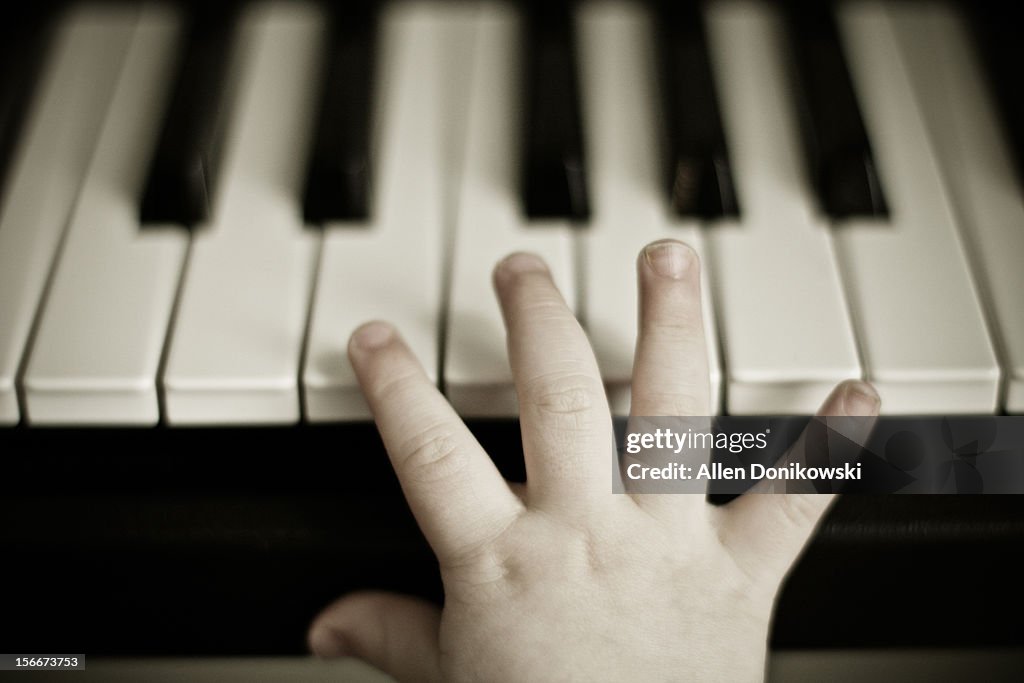 Child's hand on piano