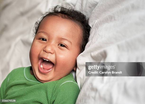 laughing baby boy showing new teeth - baby tooth stock-fotos und bilder