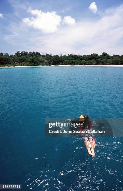 india, surfer paddling to little andaman island. - andamanensee stock-fotos und bilder