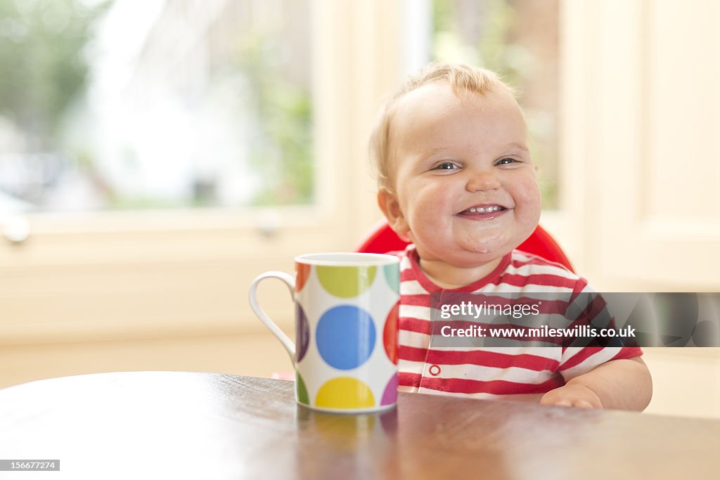 Baby girl smiles in high chair