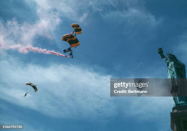 Members of the US Army Parachute Team, also known as the 'Golden Knights', descending near the Statue of Liberty in New York, July 3rd 1978. The...