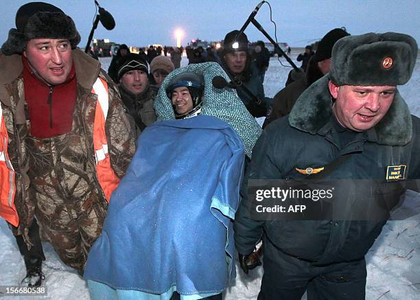 Russian space agency rescuers carry a crew member of the International Space Station , Japanese astronaut Akihiko Hoshide, shortly after his landing...