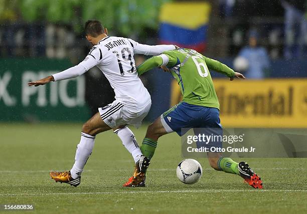 Osvaldo Alonso of the Seattle Sounders FC dribbles against Juninho of the Los Angeles Galaxy during Leg 2 of the Western Conference Championship at...