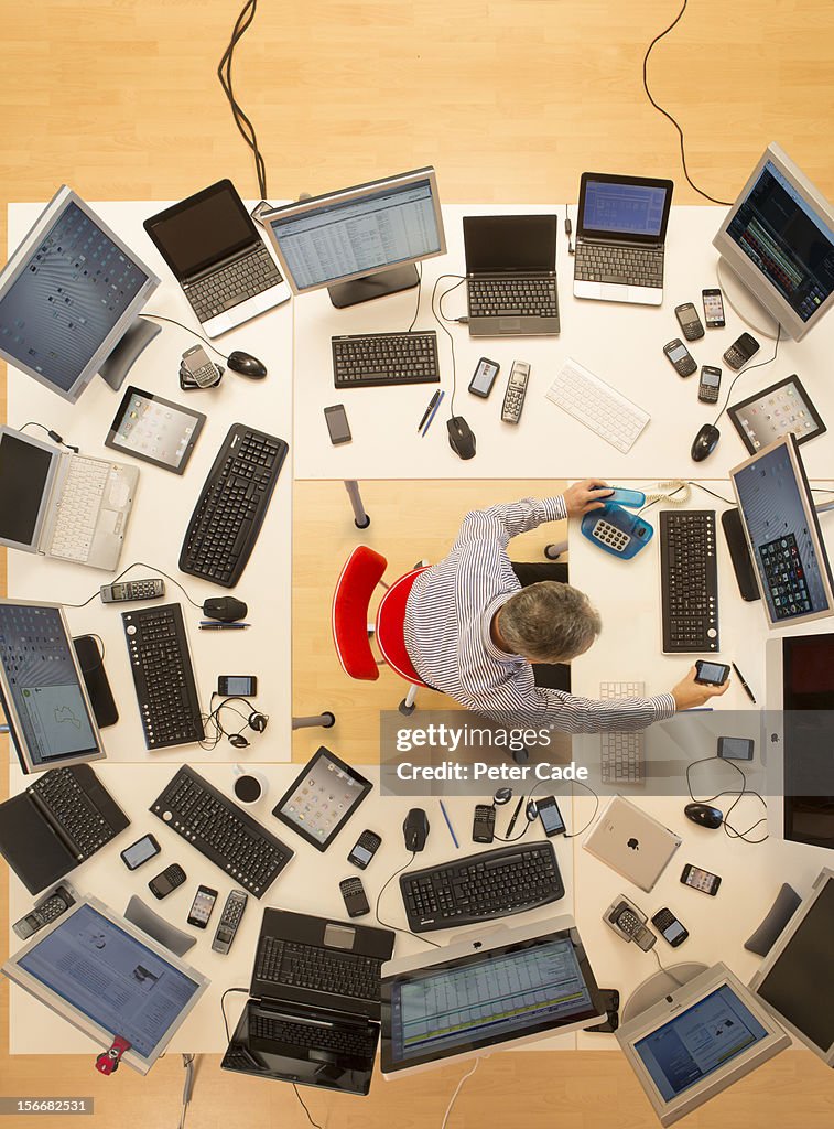 Man surrounded by desks and computers