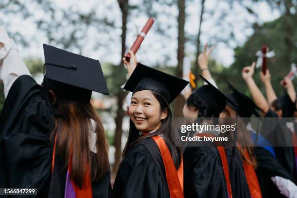 asian female graduate smiling and holding diploma certificate in university campus - the bachelor stockfoto's en -beelden