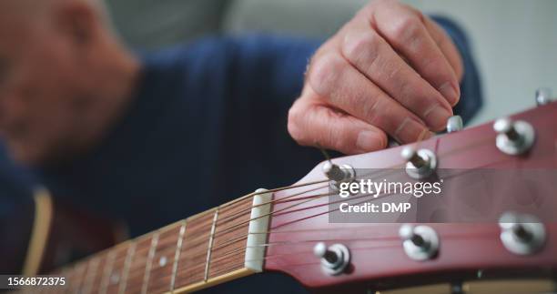 man, tuning guitar and hands in home living room to play song for music in house. person, acoustic instrument and musician check notes in lounge for sound, audio and creative closeup for performance - jazz music guitar stock pictures, royalty-free photos & images