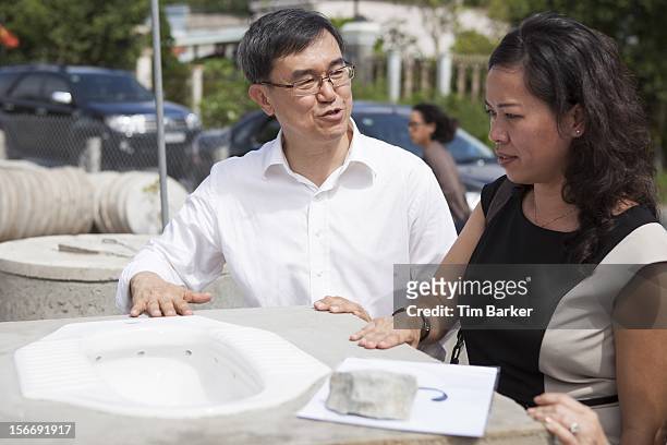 Of World Toilet Organisation Mr. Jack Sim talks with Marketing Vice President of Unilever Vietnam Nguyen Thi Bich Va at a toilet production center as...