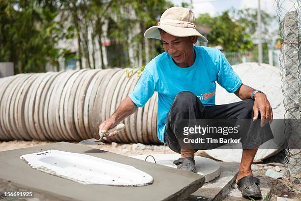 Sanishop employee Nguyen Thanh Liem finishes off a toilet at the Toilet Production Center as part of a media briefing on World Toilet Day on November...