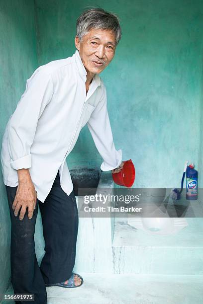 Nguyen Van Tu flushes some water down his new toilet, which has been recently installed, as part of a media briefing on World Toilet Day on November...