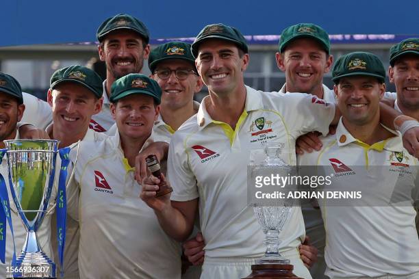 Australia's Pat Cummins holds the urn trophy as Australia celebrate the drawn series and retaining The Ashes after England's victory on day five of...