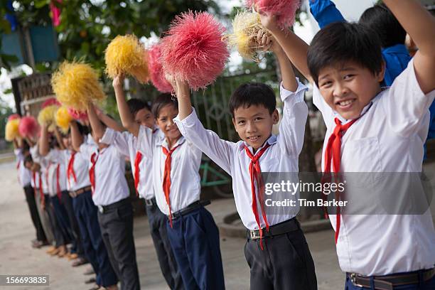 Pupils from the Le Thanh Van Primary School wave pom poms as they greet dignitaries arriving for the inauguration of the new toilet complex on World...