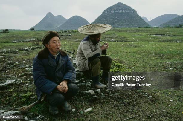 Minority farmers taking a break from working in the Guizhou province, China, 26th March 1997.