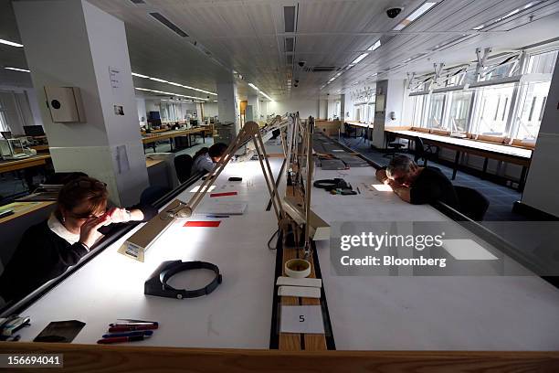 Employees use angled lights and magnifying glasses to sort uncut diamonds at at the De Beers office in London, U.K., on Friday, Nov. 16, 2012. De...
