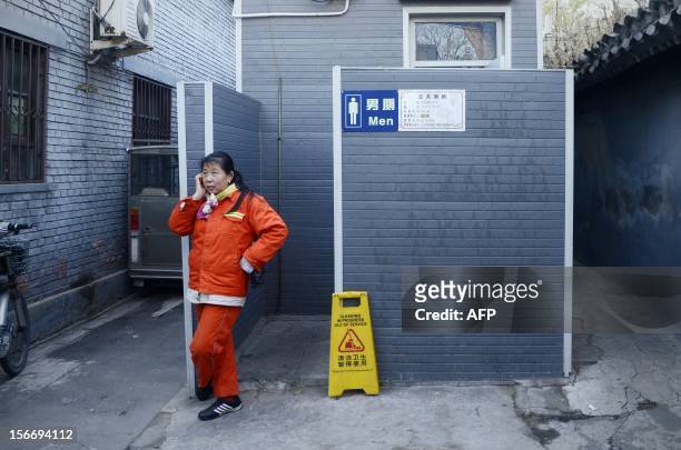 Woman makes a call next to a toilet in Beijing on November 19, 2012. In 2001 the World Toilet Organization declared November 19 as World Toilet Day...