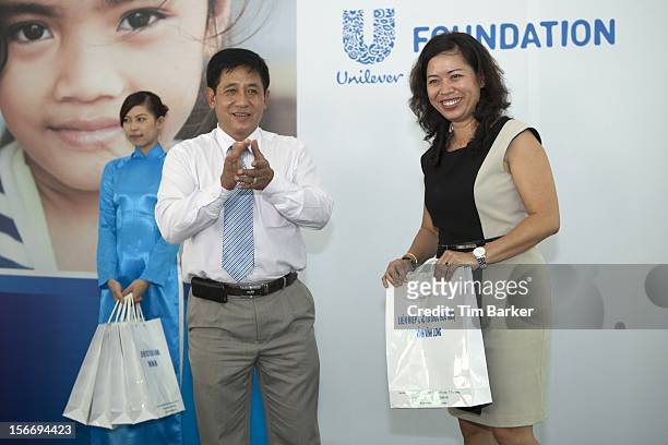 Chief of Staff Vinh Long Peoples Commitee Nguyen Hoang Hoc presents a symbol of appreciation to Marketing Vice President of Unilever Vietnam Ms....