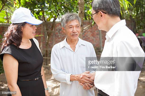 Marketing Vice President of Unilever Vietnam Nguyen Thi Bich Va looks on as Nguyen Van Tu shakes the hand of CEO of World Toilet Organisation Jack...