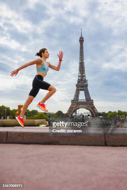 young woman running on the town square near eiffel tower in paris - paris sport stock pictures, royalty-free photos & images