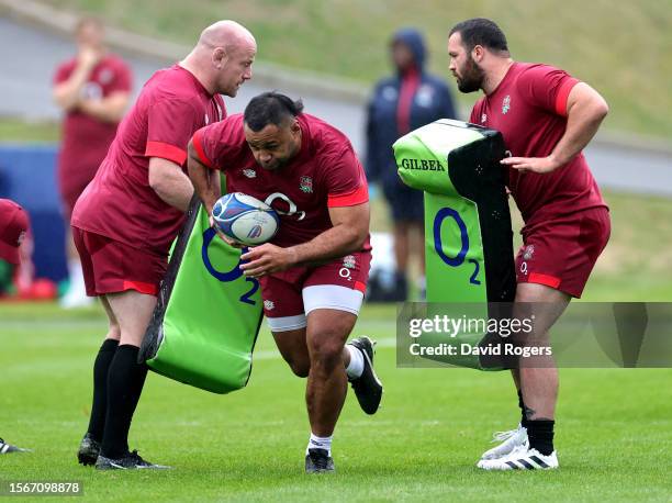 Billy Vunipola breaks through the tackle bags held by team mates Dan Cole and Bevan Rodd during the England training session held at Pennyhill Park...