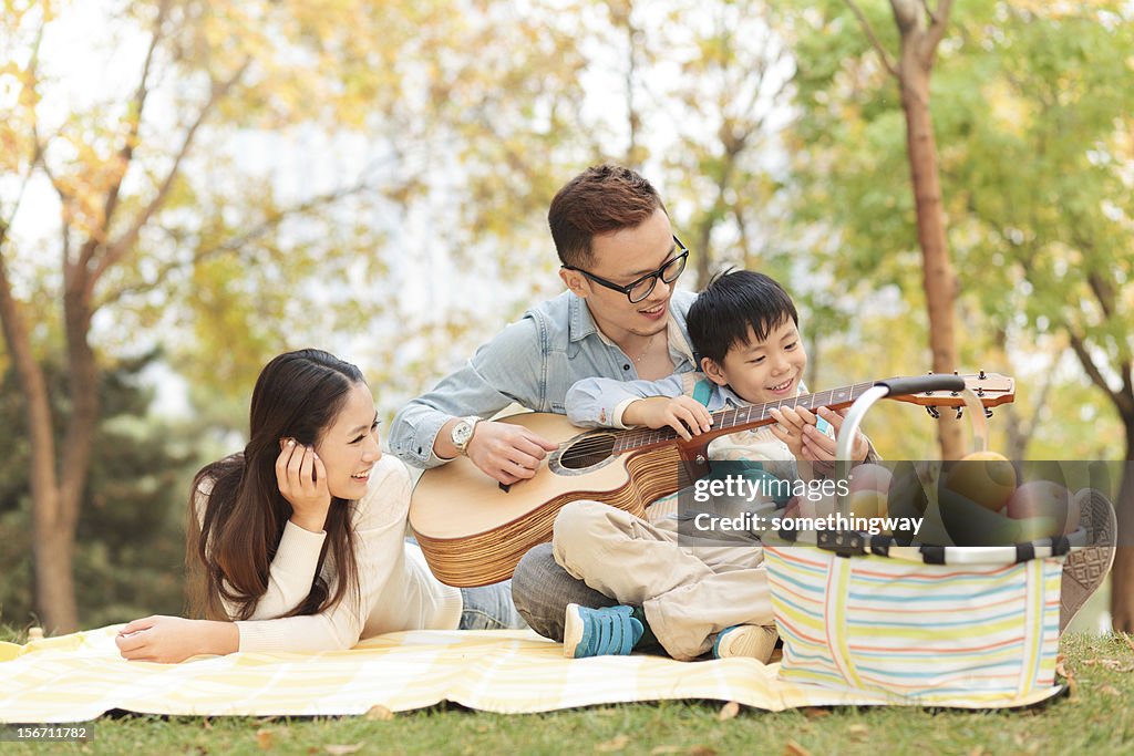 Tocar Guitarra família feliz no parque