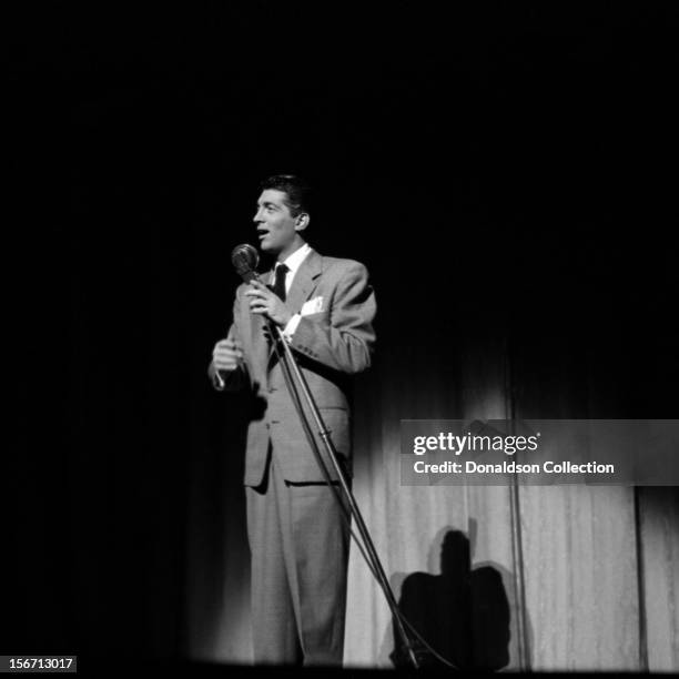 Singer and actor Dean Martin performs on stage at the Paramount Theatre in July 1951 in New York City, New York.