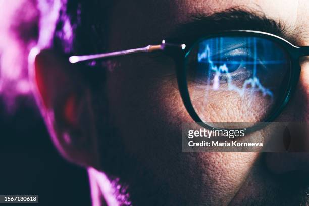 close-up portrait of man working on computer. сhart reflecting in glasses. data analytics statistics information business technology. - certificado de una acción fotografías e imágenes de stock