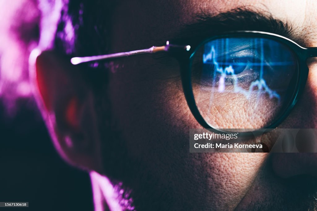 Close-up Portrait of man Working on Computer. Сhart Reflecting in Glasses. Data Analytics Statistics Information Business Technology.