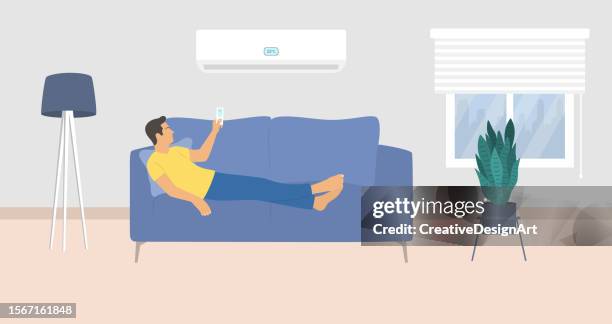 stockillustraties, clipart, cartoons en iconen met young man lying down on couch and turning on air conditioner with remote controller - ac weary