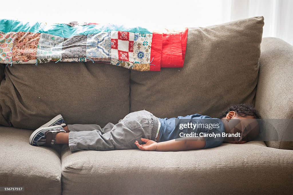 Toddler boy sleeping straight on couch