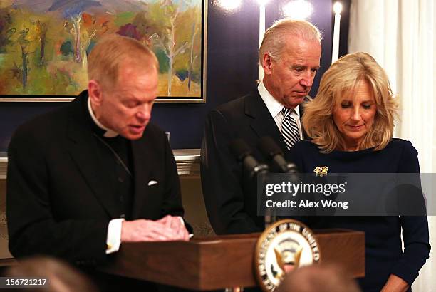 White House Military Chaplain Stanley Fornea leads to say a prayer for the meal as U.S. Vice President Joseph Biden and his wife Jill Biden bow their...