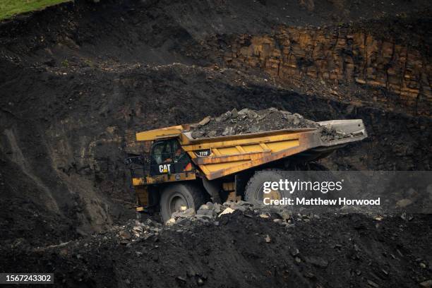 Trucks carry material at Ffos-y-Fran open-cast coal mine on July 31, 2023 in Merthyr Tydfil, Wales. Activity at the Ffos-y-Fran open-cast coal mine...