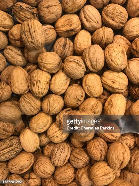 closeup of pile of fresh organic whole walnuts. fresh produce crop at farmers market in the uk in march 2023 - walnut farm stock pictures, royalty-free photos & images