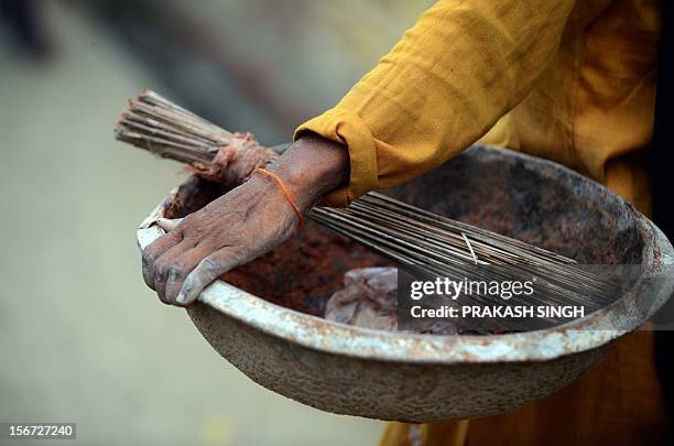 By Adam Plowright In this picture taken on August 10 shows a manual scavenger carrying tools of her profession, a basket, a broom and plastic shovel,...