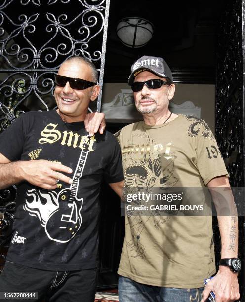 French Rock Star Johnny Hallyday poses with his business partner, fashion designer Christian Audigier , owner of the "Smet" fashion line, in Los...