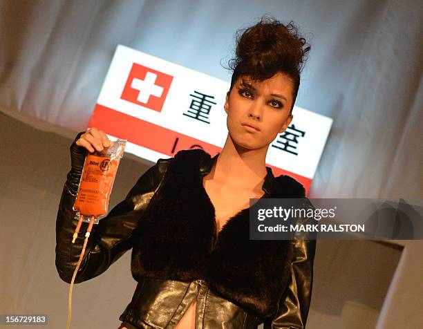 Model carries an IV bag during the "Toxic Threads - The Big Fashion Stitch-up" fashion parade organized by environment action group Greenpeace to...