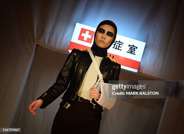 Chinese model with her arm in a sling walks during the "Toxic Threads - The Big Fashion Stitch-up" fashion parade organized by Greenpeace to...