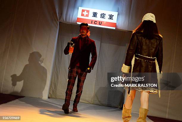 Chinese model carries an IV bag during the "Toxic Threads - The Big Fashion Stitch-up" fashion parade organized by Greenpeace to highlight chemical...