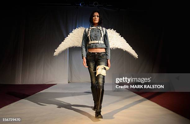 Chinese model with angel wings and a bandaged leg walks during the "Toxic Threads - The Big Fashion Stitch-up" fashion parade organized by Greenpeace...