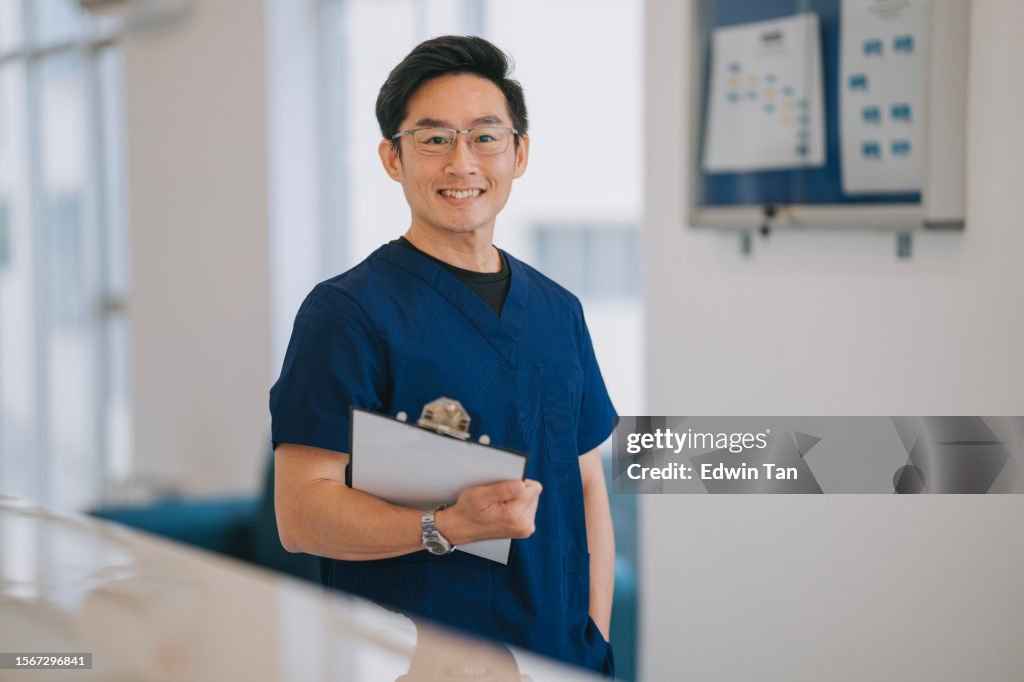 Portrait asian male nurse looking at camera smiling standing in front of doctor's office