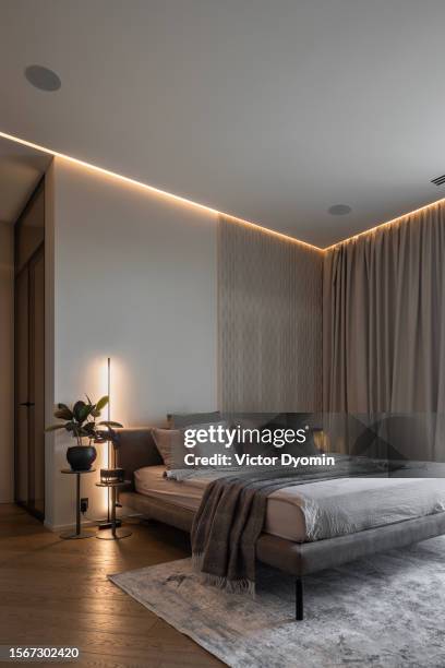 stylish modern bedroom with soft illumination and large bed - bedroom ceiling stock pictures, royalty-free photos & images