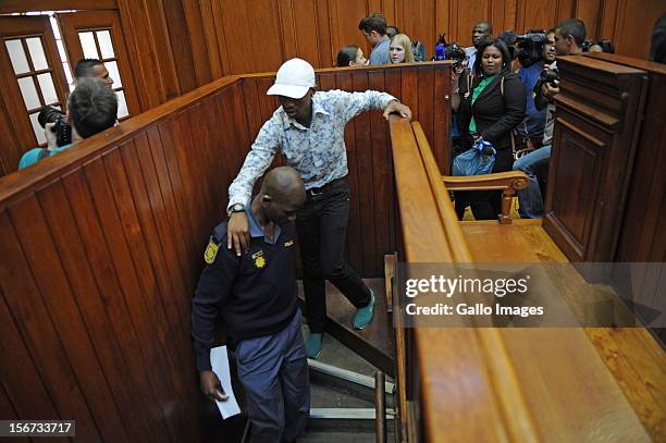 Xolile Mngeni is assisted by a police officer in the Cape Town High Court on November19, 2012 in Cape Town, South Africa. Mngeni was found guilty of...