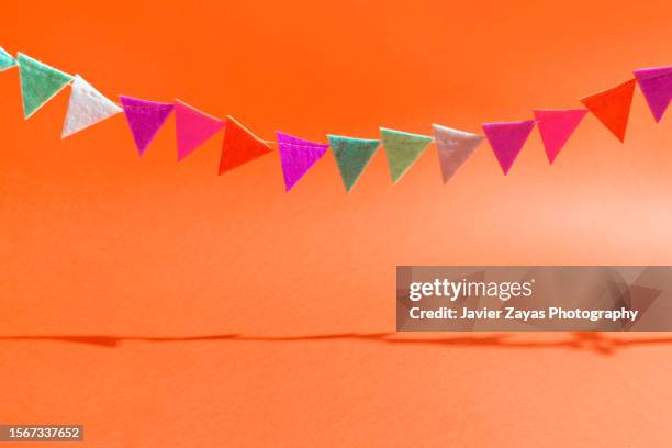 felt paper garland on red background - garland of flags stock pictures, royalty-free photos & images