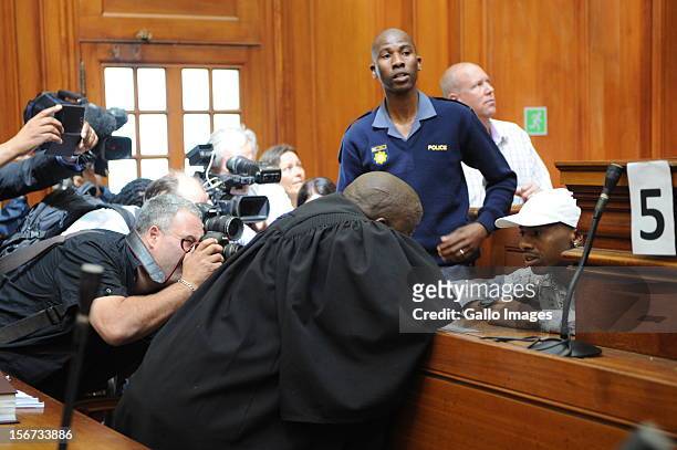 Xolile Mngeni is surrounded by photographers in the Cape Town High Court on November19, 2012 in Cape Town, South Africa. Mngeni was found guilty of...