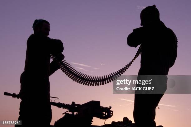 Israeli soldiers inspect a belt of bullets of the machine gun of a tank at an Israeli army deployment area near the Israel-Gaza Strip border for a...